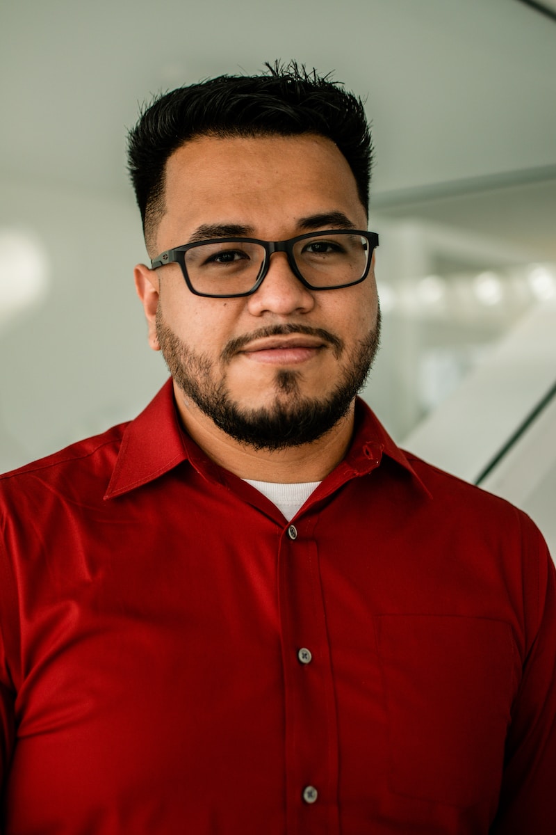 man in red button up shirt wearing black framed eyeglasses